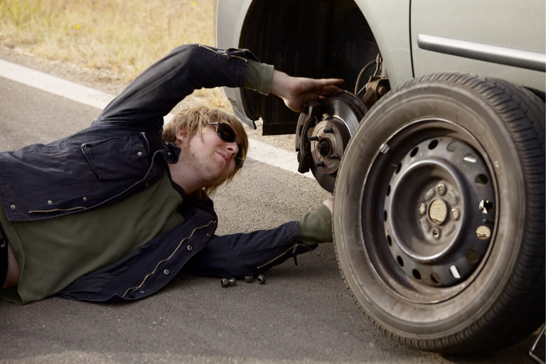 a mechanic visually inspecting the brakes